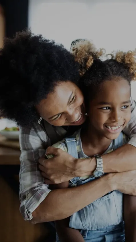 Mãe e filha abraçadas, sorrindo